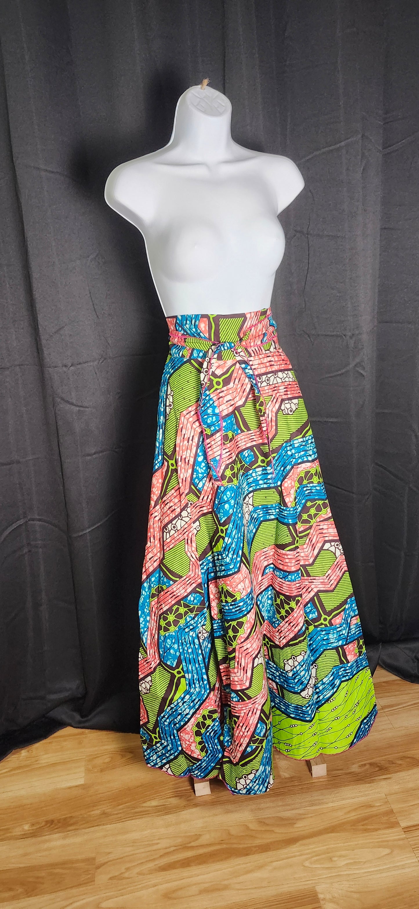 Colorful green, blue and red patterned flare dress tied with belt