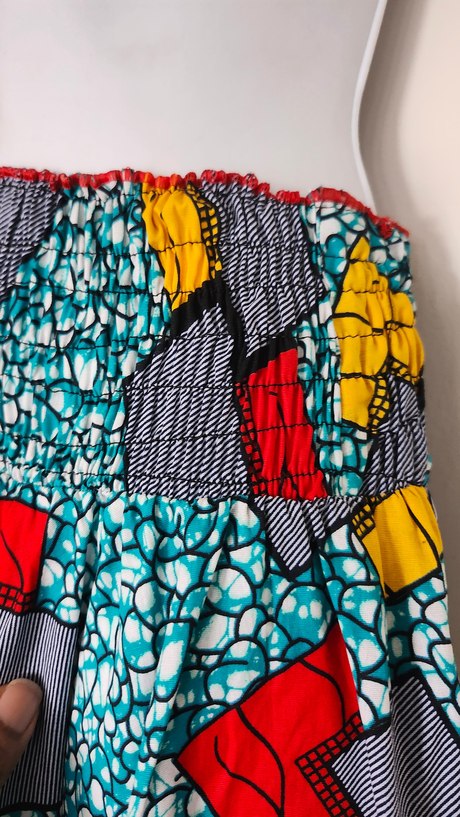 Close up Elastic waist Colorful fabric with a pattern of red, yellow, and blue shapes on a white background