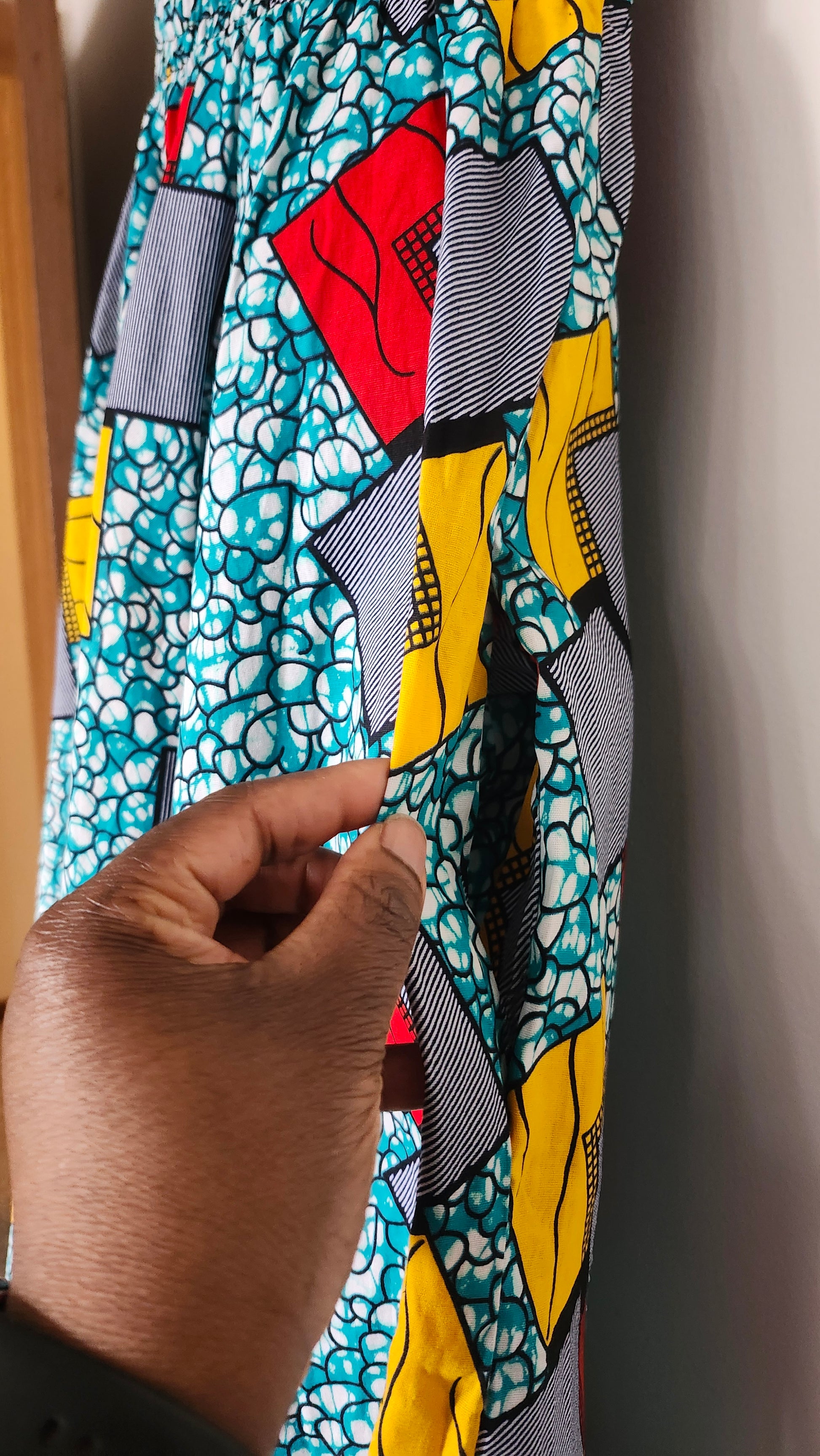 Colorful fabric with geometric patterns close up showing pocket on left 