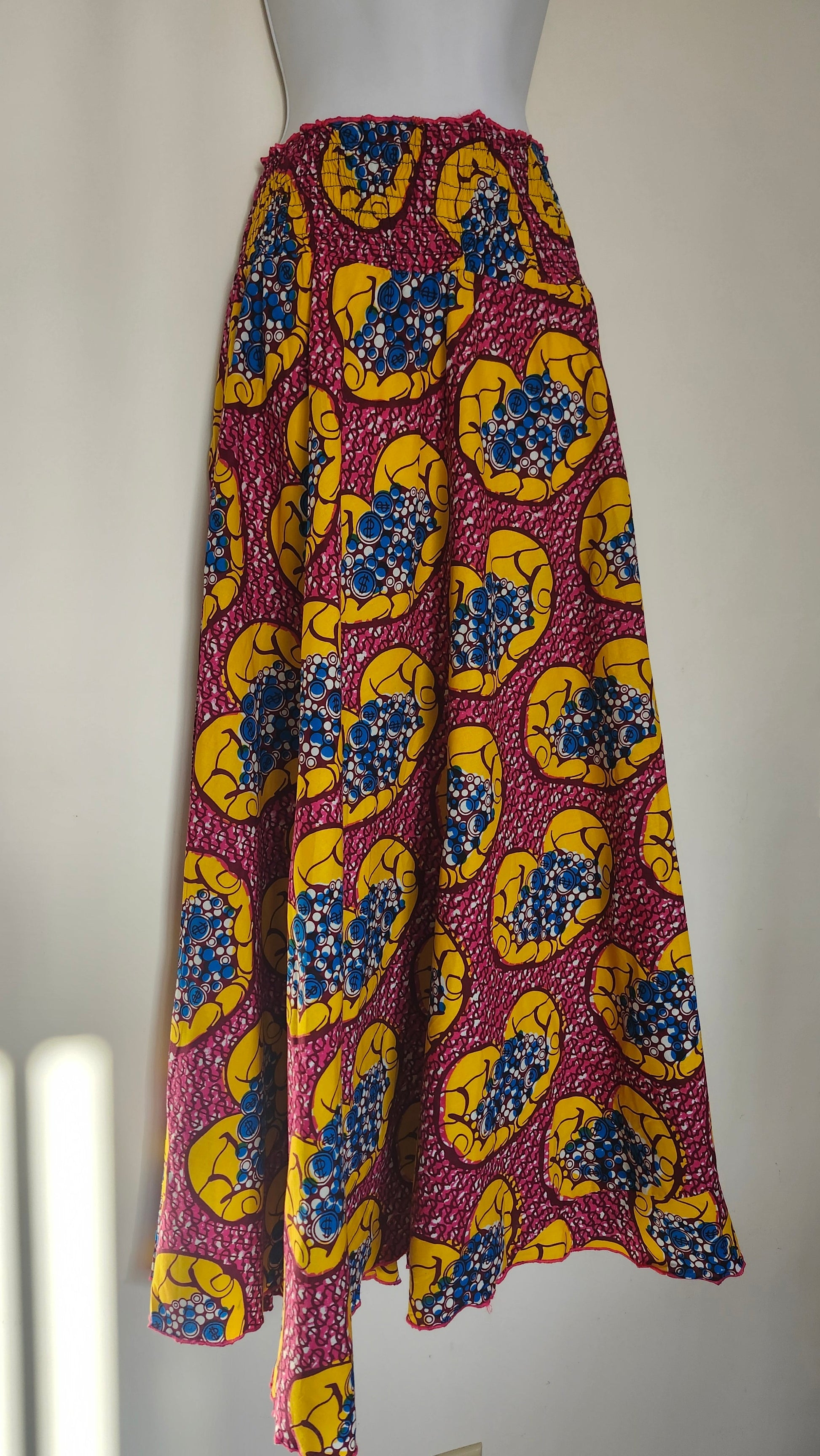 Dark Red, yellow and blue fabric with a colorful pattern on a white surface