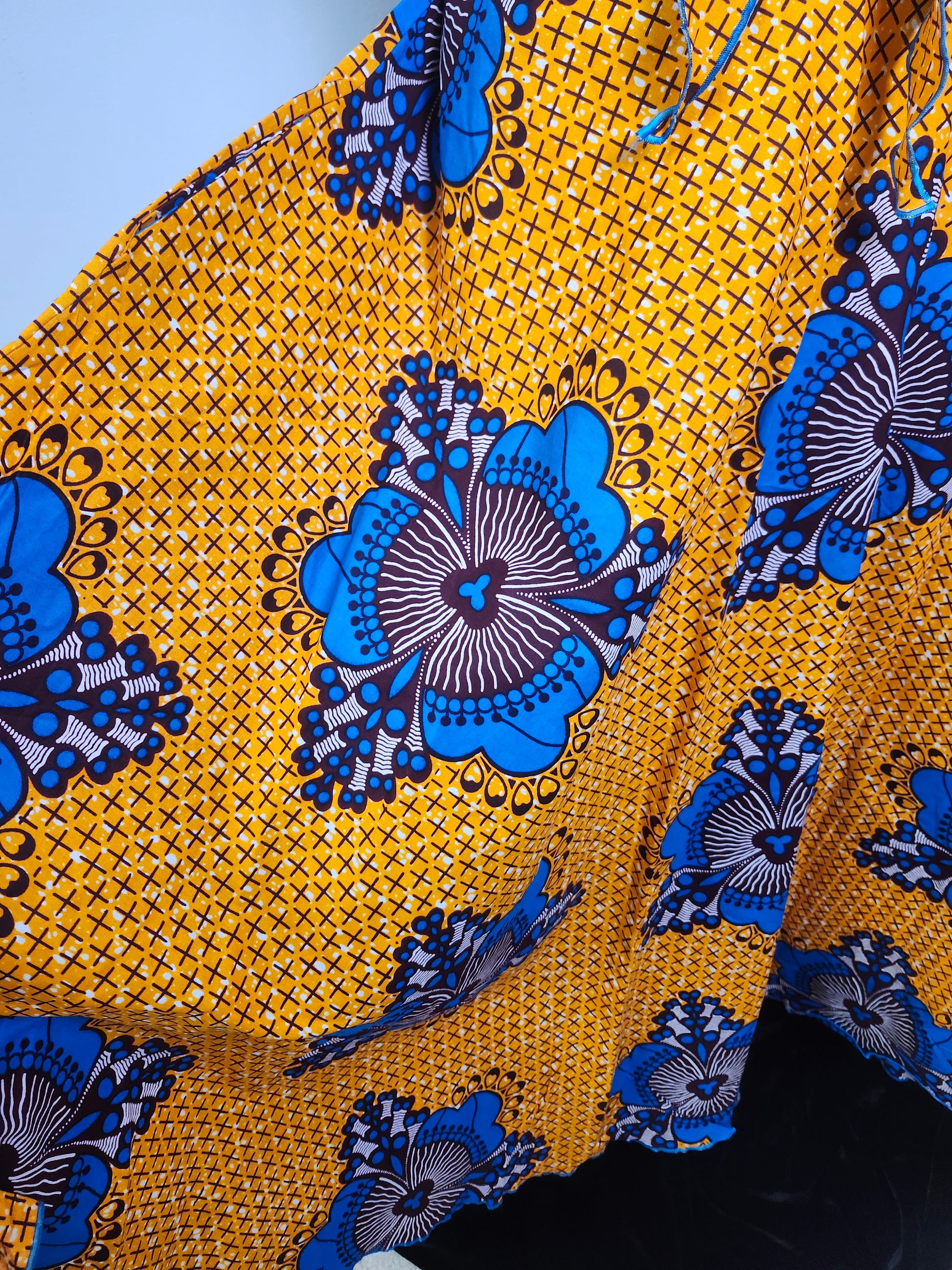 Close-up of yellow fabric with blue floral patterns