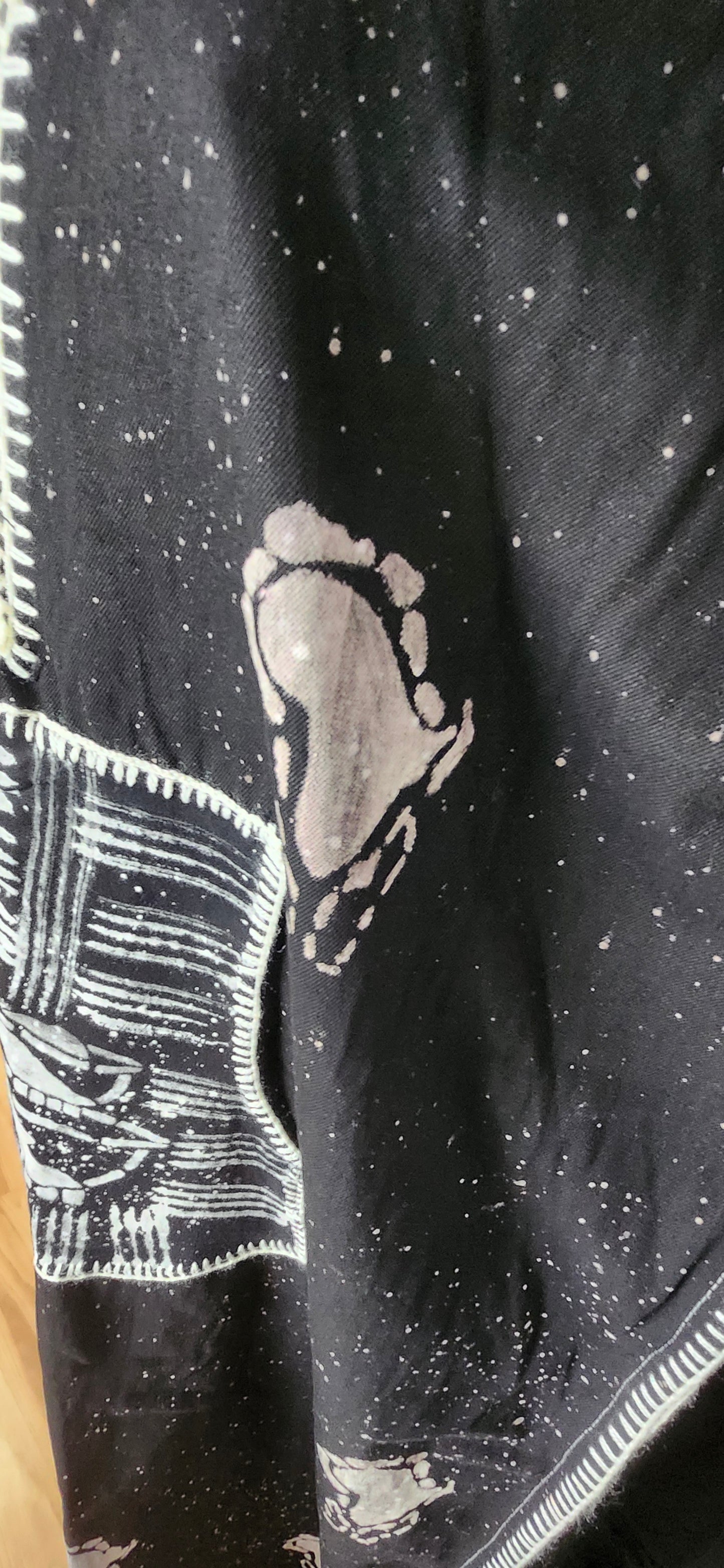 Black fabric with white African map pattern and a knitted texture.