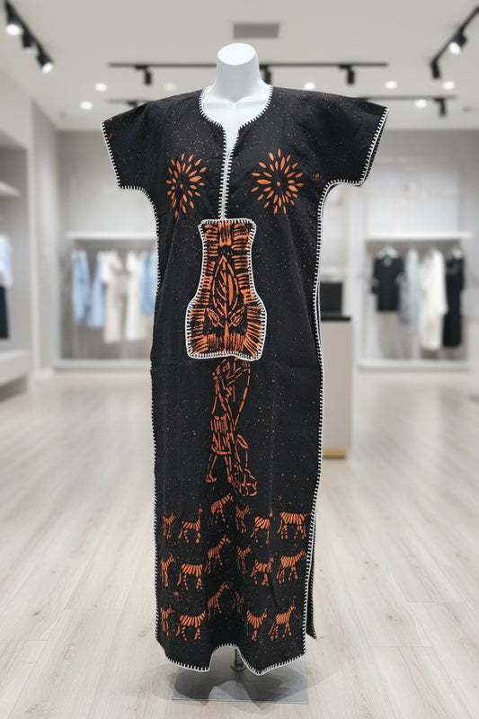 Black garment with orange embroidery on a wooden surface
