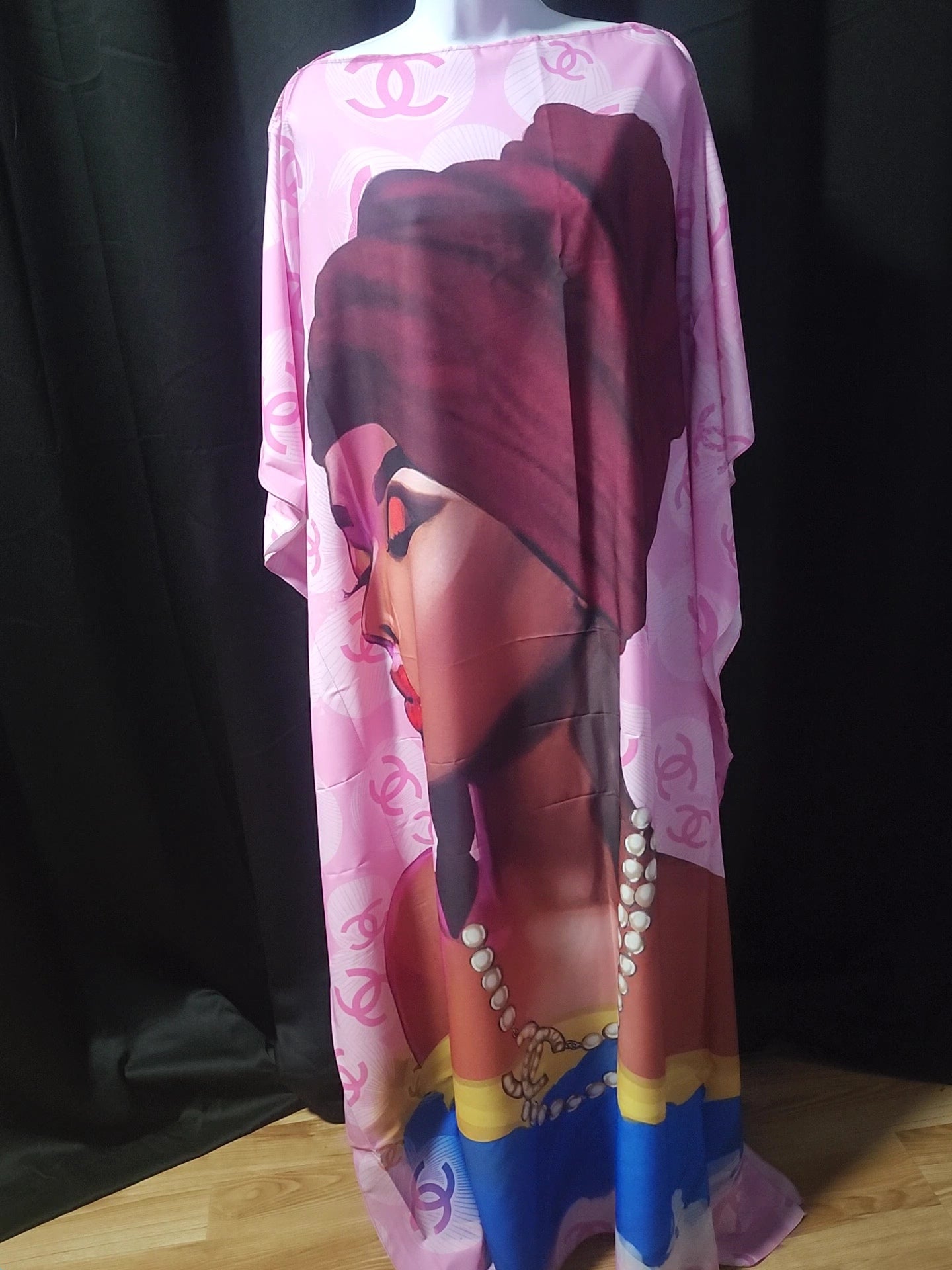 Mannequin wearing a colorful dress with a graphic design on a dark background
