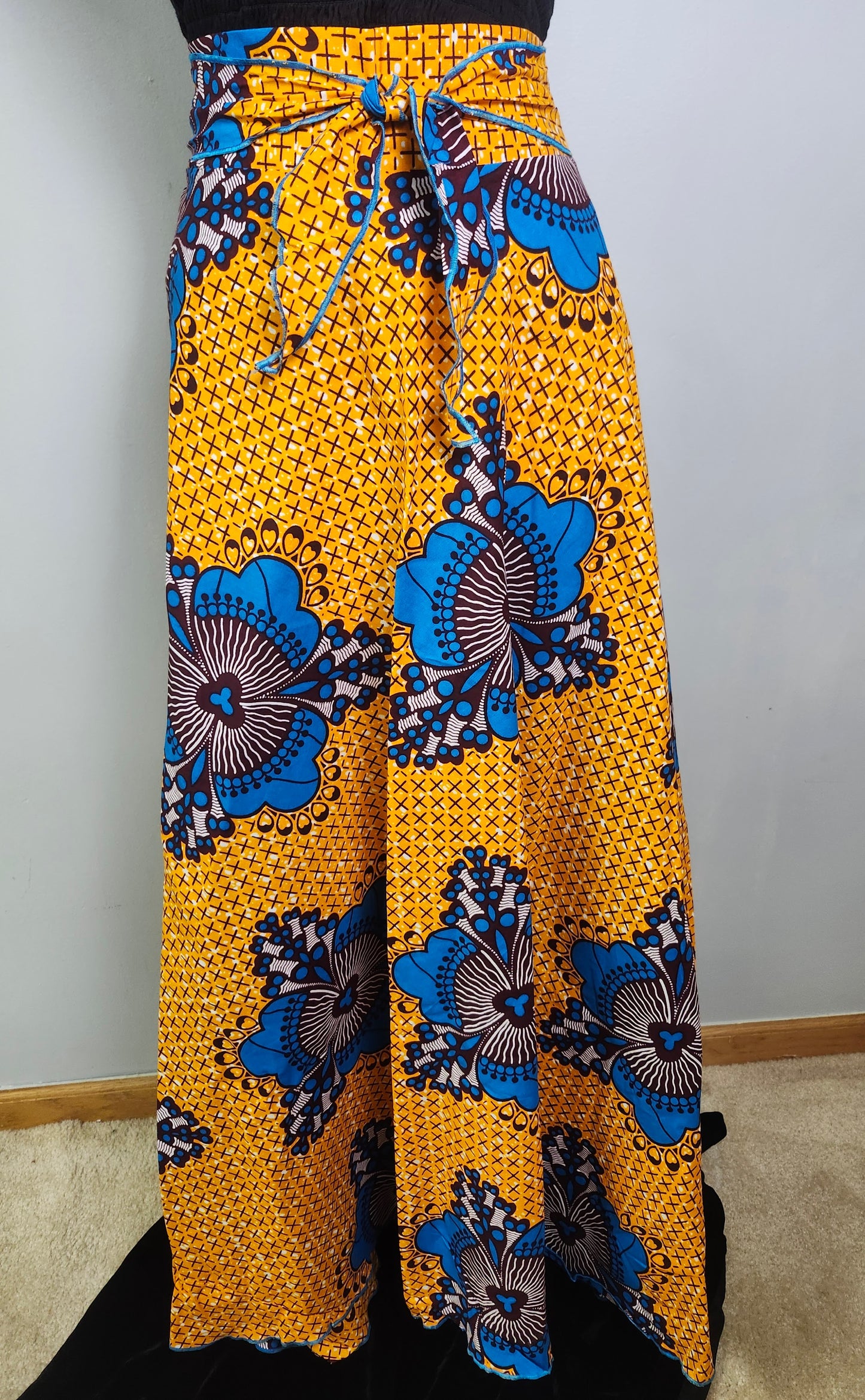 Yellow pants with blue floral patterns on a plain background