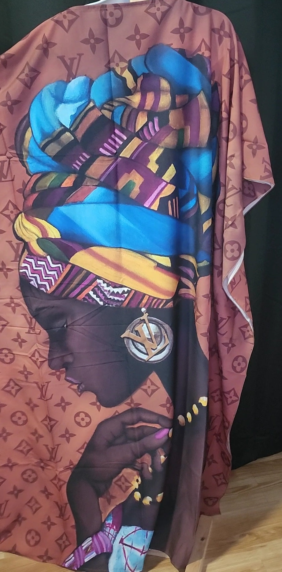 Colorful scarf with a pattern of a woman's face and geometric shapes on a dark background